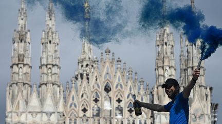 Un supporter de l'Inter célèbre le titre de champion d'Italie sur la Piazza Duomo.&nbsp; (PIERO CRUCIATTI / AFP)