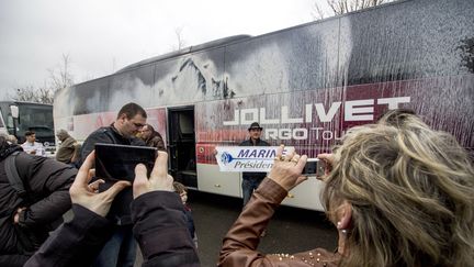 Des militants du Front national photographient un bus dégradé par des opposants à la tenue d'un meeting de Marine Le Pen à Nantes, le 26 février 2017. (MARTIN BERTRAND / AFP)