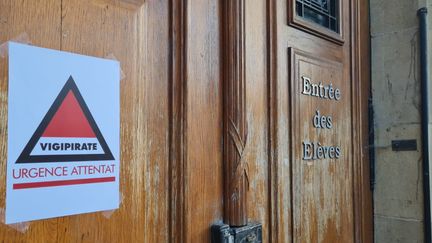 Une affiche Vigipirate urgence attentat a été accroché sur la porte de l'entrée des élèves du lycée Louis Vincent de Metz. (Radio France)