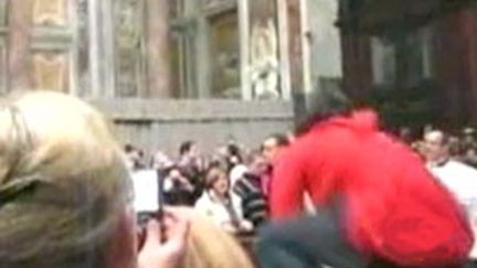 Maiolo (en rouge) saute une barrière en direction du pape en la basilique Saint-Pierre de Rome le 24 décembre 2009. (France 2)