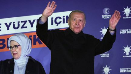Le président turc, Recep Tayyip Erdogan, salue ses partisans au côté de son épouse Ermine Erdogan, dans la nuit du 14 au 15 mai 2023, au siège de son parti AKP à Ankara (Turquie). (ADEM ALTAN / AFP)