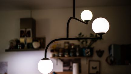 Une lampe allumée dans un salon à Paris, le 16 juillet 2021. (XOSE BOUZAS / HANS LUCAS / AFP)