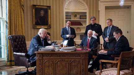 Donald Trump au téléphone avec Vladimir Poutine, devant ses conseillers, dans le bureau ovale, à la Maison Blanche, le 28 janvier 2017. (GETTY IMAGES)