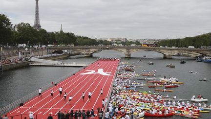 Paris a installé sur la Seine, le 23 juin 2017, une piste d'athlétisme pour&nbsp;célébrer la journée qui marque la création du Comité international olympique par Pierre de Coubertin le 23 juin 1894. (JACQUES DEMARTHON / AFP)