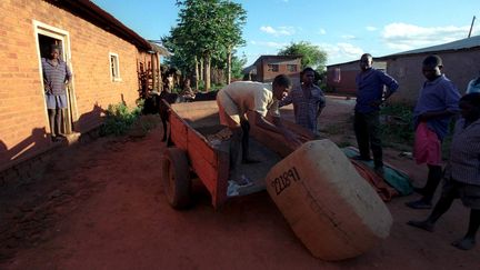 Des ouvriers déchargent une balle de feuilles de tabac dans le village de Nsabwe, au centre du Malawi.&nbsp; (MAXPPP)