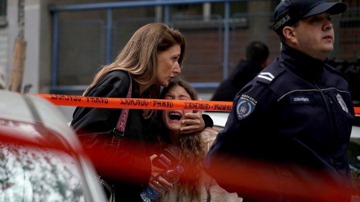 Une femme console une enfant le 3 mai 2023 à Belgrade (Serbie), après une tuerie dans une école. (OLIVER BUNIC / AFP)