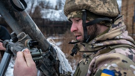 A Ukrainian soldier prepares to fire a shell towards Bakhmout, where clashes continue, on January 26, 2024. (IGNACIO MARIN / ANADOLU / AFP)