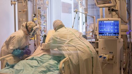 Un patient en réanimation au secteur Covid-19 du CHU de Brest est entouré de personnel médical. (QUEMENER YVES-MARIE / MAXPPP)