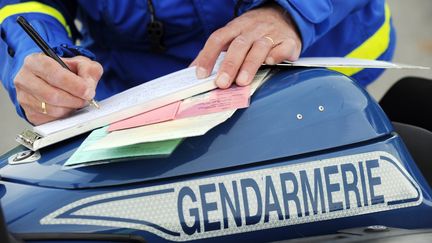 Un gendarme rédige une contravention, le 1er juin 2014, au Pellerin, près de Nantes (Loire-Atlantique). (JEAN-SEBASTIEN EVRARD / AFP)