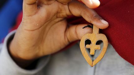 Une réfugiée chrétienne venue d'Eryhtrée montre son crucifix en bois (PASCAL ROSSINGOL / REUTERS)