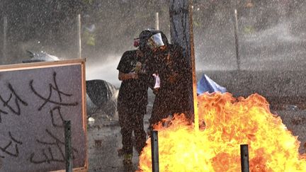 Des manifestants jettent des cocktails Molotov sur les policiers, aux abords de l'Université polytechnique de Hong Kong, le 17 novembre 2019. (PHILIP FONG / AFP)