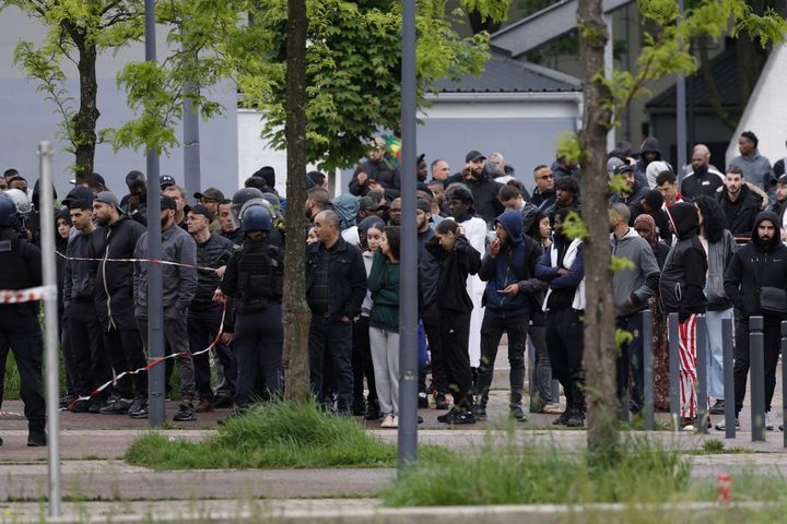 Des habitants de Sevran (Seine-Saint-Denis) derrière le cordon de sécurité des forces de l'ordre après une fusillade, le 5 mai 2024. (GEOFFROY VAN DER HASSELT / AFP)