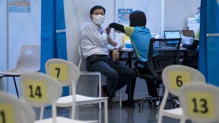 Un homme reçoit une dose du vaccin Sinovac dans un centre de vaccination à Hong Kong (23 février 2021). (PAUL YEUNG / POOL)