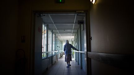 Une femme âgée marche dans un couloir d'un Ehpad près de Nantes, le 30 mars 2021. (LOIC VENANCE / AFP)