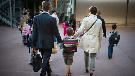 Des parents accompagnent leur enfant &agrave; l'&eacute;cole pour la rentr&eacute;e, le 3 septembre 2013, &agrave; Paris. (MARTIN BUREAU / AFP)