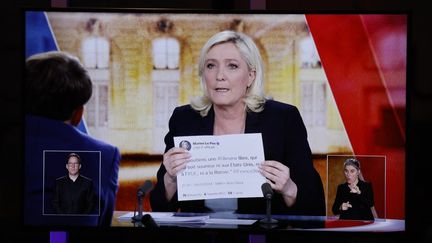 Marine Le Pen arbore un tweet imprimé lors du débat de l'entre-deux-tours de la présidentielle avec Emmanuel Macron, le 20 avril 2022. (LUDOVIC MARIN / AFP)