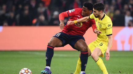 L'attaquant de Lille Jonathan David au duel avec le milieu de terrain de Chelsea, Jorginho, lors du 8e de finale retour de la Ligue des champions, le 16 mars 2022. (FRANCK FIFE / AFP)