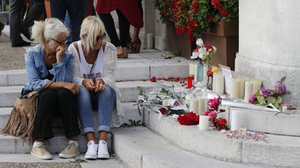 Deux femmes se recueillent devant l'hôtel de ville de Saint-Etienne-du-Rouvray, le 26 juillet 2016. (MATTHIEU ALEXANDRE / AFP)