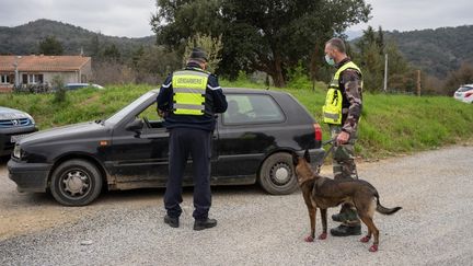 Des gendarmes français contrôlent des conducteurs traversant la frontière entre l'Espagne et la France, à Le Perthus (Pyrénées-Orientales), le 6 mars 2021. (JEANNE MERCIER / HANS LUCAS / AFP)