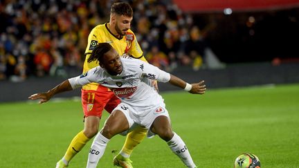 Jonathan Clauss au duel avec Souleyman Doumbia&nbsp;lors du match de Ligue 1 entre Lens et Angers, le 26 novembre 2021 au stade Bollaert de Lens. (FRANCOIS LO PRESTI / AFP)