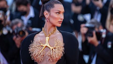 La mannequin Bella Hadid en Schiaparelli robe longue à manches longues en crêpe de laine noir avec décolleté sous la poitrine laissant apparaître un collier bijou en laiton doré, en forme de Poumons dont les bronchioles sont parsemées de strass. le 11 juillet 2021 (MARC PIASECKI / FILMMAGIC)