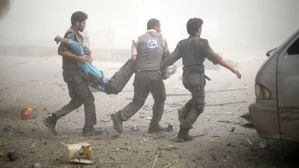 Des secouristes syriens portent une victime apr&egrave;s des frappes a&eacute;riennes sur Douma, pr&egrave;s de Damas (Syrie), le 16 ao&ucirc;t 2015. (SAMEER AL-DOUMY / AFP)