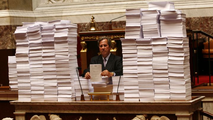 Jean Louis Debr&eacute;, alors pr&eacute;sident de l'Assembl&eacute;e nationale, pose devant les plus de 137 000 amendements contre le projet de loi sur la fusion GDF Suez, le 5 septembre 2006 &agrave; l'Assemblee nationale (Paris). (OLIVIER LEJEUNE / MAXPPP)