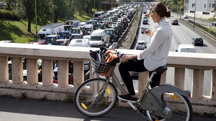 Depuis ce pont, une Parisienne regarde passer un cort&egrave;ge de tracteurs sur le p&eacute;riph&eacute;rique. (CHARLES PLATIAU / REUTERS / X00217)