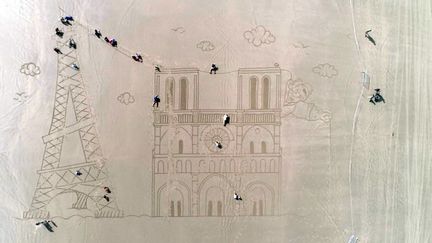 Au championnat du monde d'alpinisme horizontal, on gravit la Tour Effel et la cathédrale Notre Dame, dessinées sur le sable, par l'artiste JBen (©L. Pelletier / France 3 Poitou-Charentes)