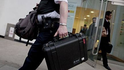 Un policier quitte le si&egrave;ge d'Alstom &agrave; Londres (Royaume-Uni), le 24 mars 2010, apr&egrave;s l'arrestation de trois responsables soup&ccedil;onn&eacute;s de corruption. (WARREN ALLOTT / AFP)