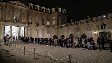Des dizaines de personnes font la queue dans la cour de l'Elysée pour rendre hommage à Jacques Chirac, le 26 septembre 2019. (GEOFFROY VAN DER HASSELT / AFP)