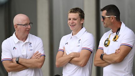 Léon Marchand entouré de ses entraîneurs Bob Bowman (à gauche) et Nicolas Castel (à droite), lors d'un stage au Canet-en-Roussillon, le 7 juin 2022. (KEMPINAIRE STEPHANE / AFP)