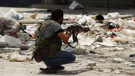 Un soldat de l'Arm&eacute;e syrienne libre patrouille dans le quartier Al-Sukkari d'Alep (Syrie), le 29 juillet 2012.&nbsp; (ZOHRA BENSEMRA / REUTERS)