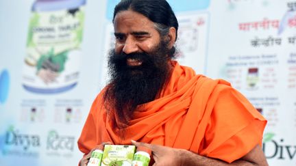 Baba Ramdev, montrant un produit&nbsp;censé guérir&nbsp;le Covid, fabriqué par son entreprise Patanjali, en février 2021 (HINDUSTAN TIMES / HINDUSTAN TIMES)