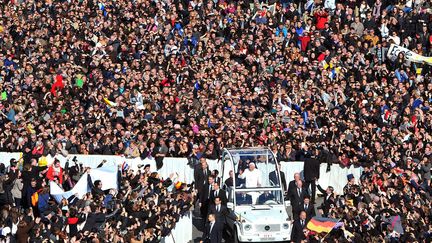 A 10H39, le pape est apparu sur fond d'orgue &agrave; bord de sa c&eacute;l&egrave;bre papa-mobile d&eacute;capot&eacute;e, et a entam&eacute; un long tour de la place pour saluer et b&eacute;nir les fid&egrave;les. (TIZIANA FABI / AFP)