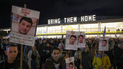 Des manifestants brandissent des photos d'Itay Svirsky, pris en otage par le Hamas, lors d'un rassemblement à Tel-Aviv, le 27 janvier 2024. (AHMAD GHARABLI / AFP)