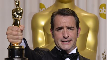 Jean Dujardin brandit son Oscar de meilleur acteur pour sa performance dans The Artist, le 26 f&eacute;vrier 2012 &agrave; Los Angeles (Etats-Unis). (JOE KLAMAR / AFP)