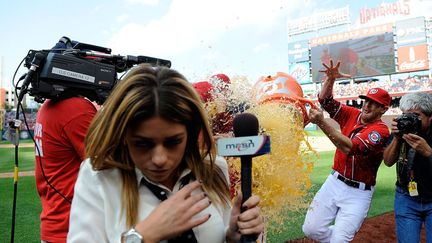 Une journaliste tente d'&eacute;viter d'&ecirc;tre asperg&eacute;e de Gatorade &agrave; l'issue du match de baseball opposant les Milwaukee Brewers aux Washington Nationals &agrave; Washington (Etats-Unis), le 22 septembre 2012. (PATRICK MCDERMOTT / GETTY / AFP)