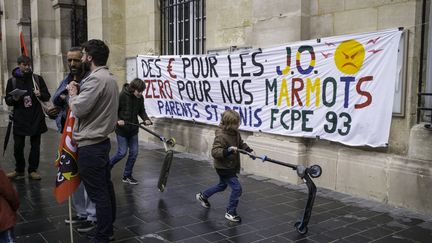 Des manifestants devant une affiche qui demande plus de moyens pour l'école publique, le 30 mars 2024 à Saint-Denis (Seine-Saint-Denis). (ERIC BRONCARD / HANS LUCAS)