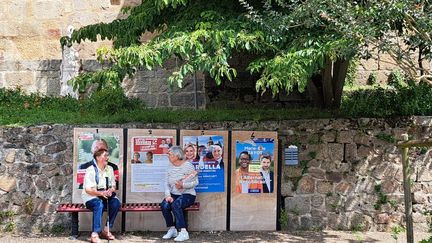 Des passantes assises devant des panneaux électoraux, à Saint-Junien (Haute-Vienne), le 9 juillet 2024. (RAPHAEL GODET / FRANCEINFO)