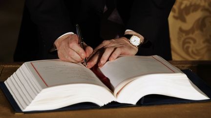 Le Premier ministre britannique Gordon Brown signe le traité de Lisbonne, le 13 décembre 2007, au Portugal. (NACHO DOCE / REUTERS)