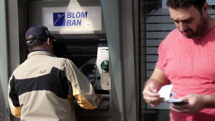 Un homme retire de l'argent à un distributeur automatique de billets à Beyrouth au Liban, le 9 novembre 2019. (ANWAR AMRO / AFP)