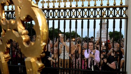 La foule devant le chevalet de faire-part de naissance du Royal Baby &agrave; Buckingham palace &agrave; Londres, le 22 juillet 2013. (JOHN STILLWELL / POOL)