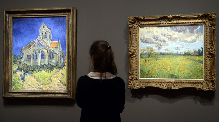 A gauche, "L'Eglise d'Auvers-sur-Oise vue du chevet". A droite, "Paysage sous un ciel de tourmente". Les deux toiles figurent parmi les &oelig;uvres de Vincent Van Gogh pr&eacute;sent&eacute;es au mus&eacute;e d'Orsay, &agrave; partir du 11 mars 2014.&nbsp; (BERTRAND GUAY / AFP)