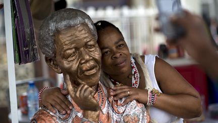 Une femme pose contre une statue e Mandela &agrave; Soweto le&nbsp;9 d&eacute;cembre&nbsp;2013 (PEDRO UGARTE / AFP)