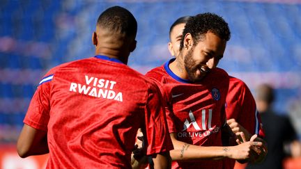 L'attaquant du PSG Kylian Mbappé porte un maillot "Visitez le Rwanda" pendant un échauffement avec Neymar au Parc des Princes à Paris, le 21 juillet 2020. (FRANCK FIFE / AFP)