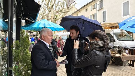 Un militant d'Emmanuel Macron interviewé par franceinfo sur le marché de Vaison-la-Romaine (Vaucluse) (Charlotte Mattout / Radio France)