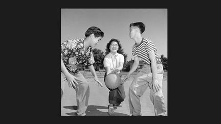 Enfants chinois jouant au basketball dans le quartier chinois de Vancouver, C.-B. Novembre 1951
 (Gouvernement canadien/Bibliothèque et Archives Canada)