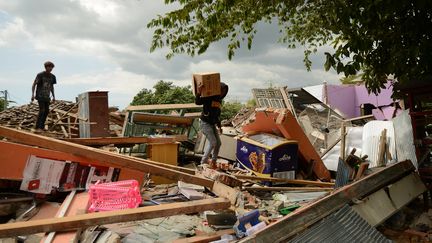 Un homme marche parmi les débris d'une maison effondrée à Kayangan, au nord de l'île de Lombok, le 9 août 2018. (SONNY TUMBELAKA / AFP)