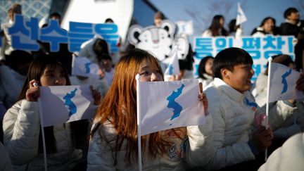 Des supporters sud-coréens brandissent le drapeau de la Corée unie avant un match amical de hockey sur glace féminin entre l'équipe de Corée et la Suède, à Incheon (Corée du Sud), le 4 février 2018. (KIM HONG-JI / REUTERS)